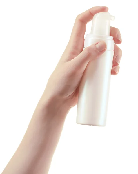 Vrouwelijke hand met cosmetica fles geïsoleerd op wit — Stockfoto