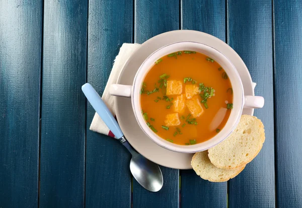 Carrot soup in bowl, on color wooden background — Stock Photo, Image