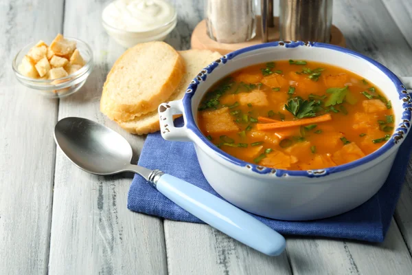 Carrot soup, cream and spoon, on  color wooden background — Stock Photo, Image