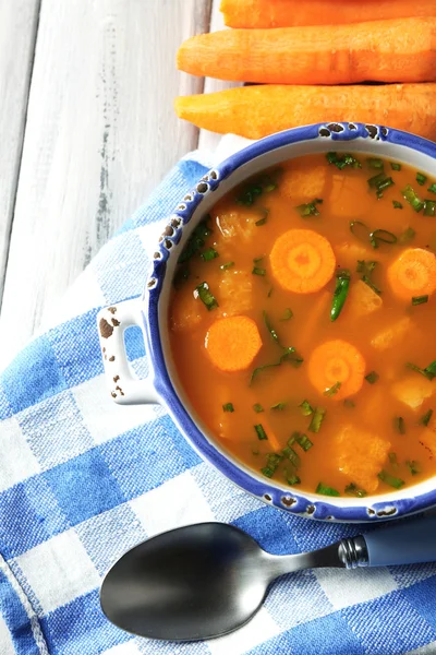 Carrot soup, cream and spoon, on  color wooden background — Stock Photo, Image