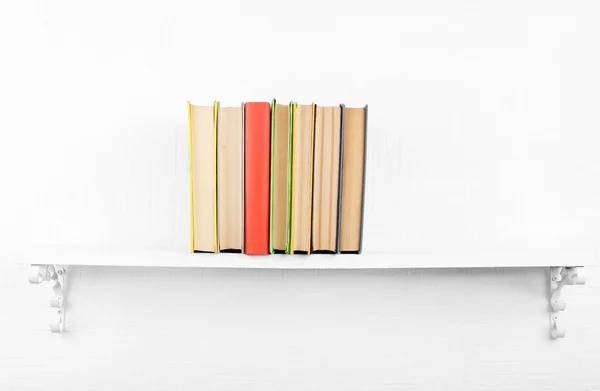 Old books on bookshelf on white wall background — Stock Photo, Image