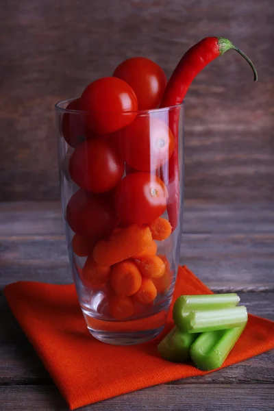 Vegetables with chili pepper in glass on napkin and rustic wooden background — Stock Photo, Image