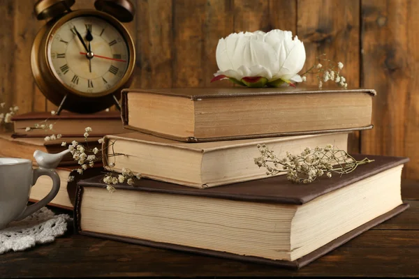 Livros com relógio sobre fundo de madeira — Fotografia de Stock