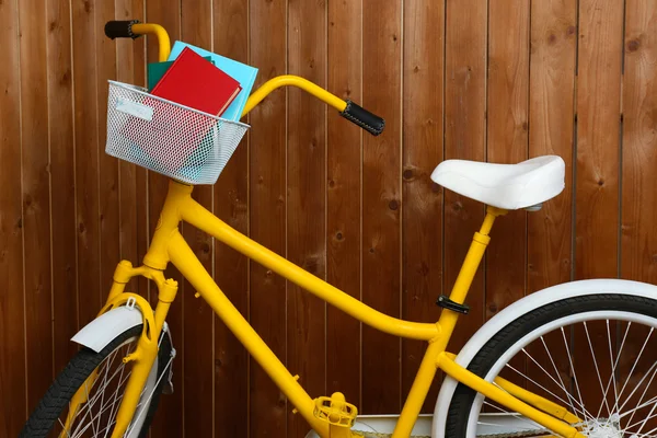 木製の壁の背景に書籍と自転車 — ストック写真