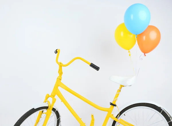 Bicicleta amarela com balões isolados em branco — Fotografia de Stock