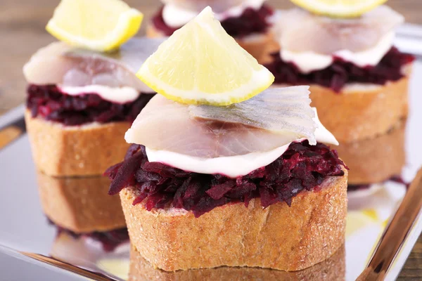 Rye toasts with herring and beets on metal tray close up — Stock Photo, Image