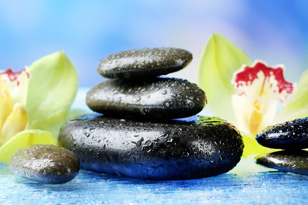 Spa stones with steam and beautiful blooming orchid — Stock Photo, Image