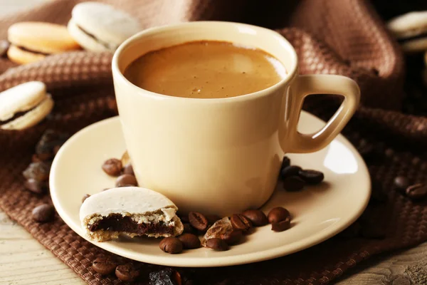 Macaroni colorati delicati e caffè in tazza su sfondo tavolo in legno — Foto Stock