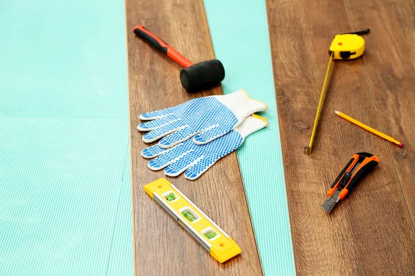 Tischlerwerkzeuge auf neuem Laminatboden — Stockfoto