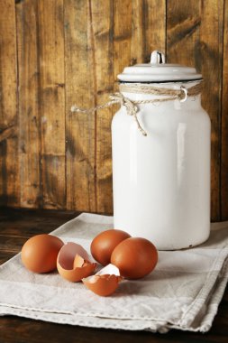Yumurta ve yumurta kabuğu rustik ahşap zemin üzerine süt olabilir