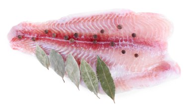 Biber ve defne yaprağı üzerinde beyaz izole Pangasius fileto