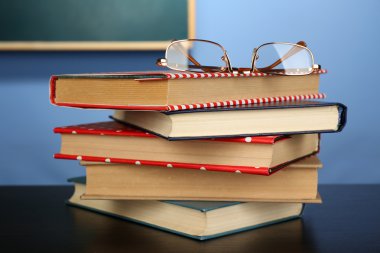 Gözlüklü kitap yığını