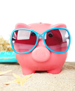 Kum, beyaz arka plan üzerinde üzerinde güneş gözlüğü ile Piggy banka