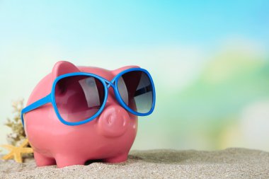 Sahilde güneş gözlüğü ile Piggy banka