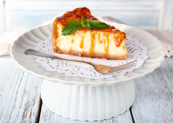 Cheese cake on paper napkin on plate on wooden background — Stock Photo, Image