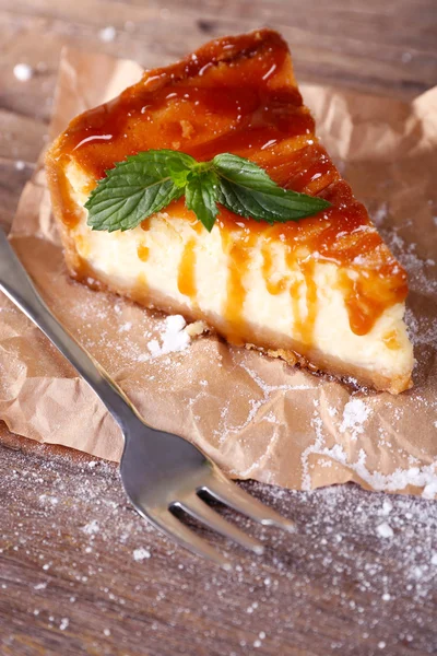 Bolo de queijo com açúcar em pó sobre papel sobre fundo de madeira — Fotografia de Stock