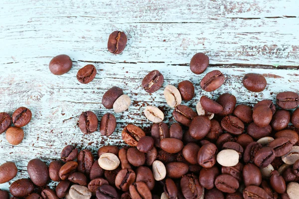 Grãos de café no fundo de madeira azul claro — Fotografia de Stock