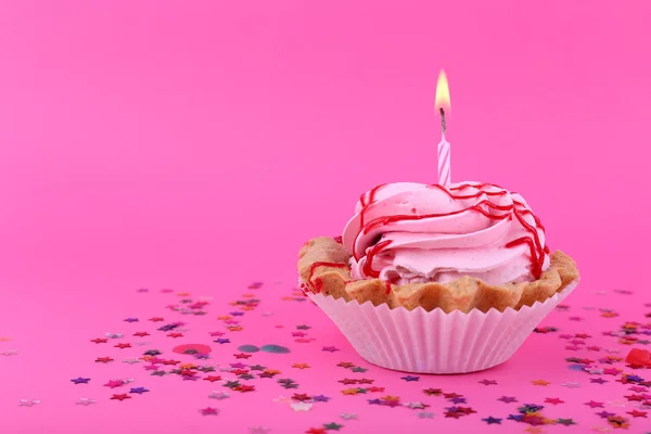 Bolo de xícara de aniversário com vela e estrelas coloridas no fundo rosa — Fotografia de Stock