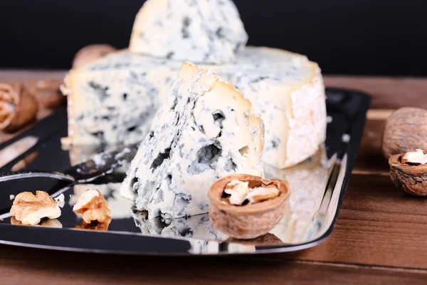 Blue cheese with nuts and blade on metal tray and wooden table and dark background — Stock Photo, Image