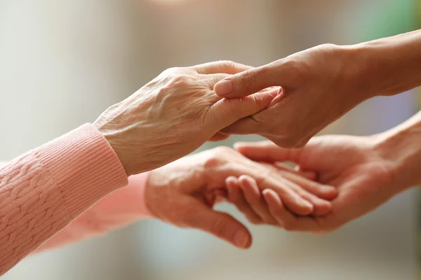 Old and young holding hands — Stock Photo, Image