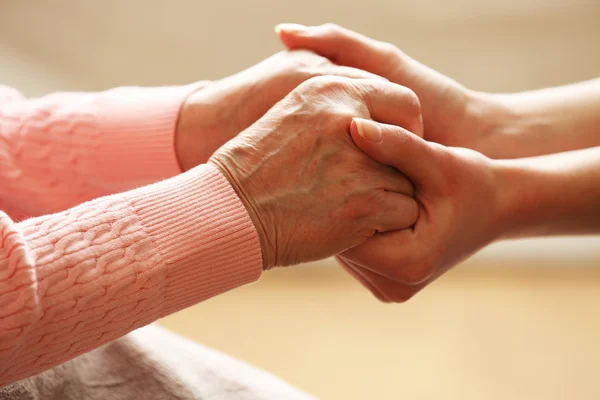 Old and young holding hands — Stock Photo, Image