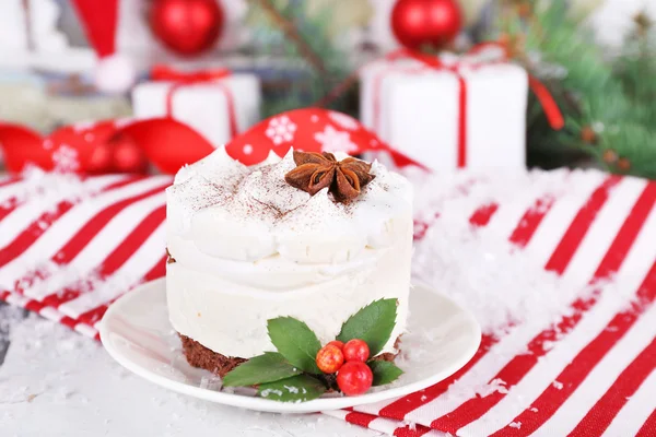 Leckeren Kuchen auf Untertasse mit Stechpalme und Beere auf Weihnachtsdekoration Hintergrund — Stockfoto