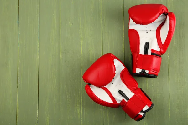 Paar Boxhandschuhe auf farbigem Holzhintergrund — Stockfoto