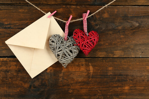 Любовное письмо висит на веревке на деревенском деревянном фоне
