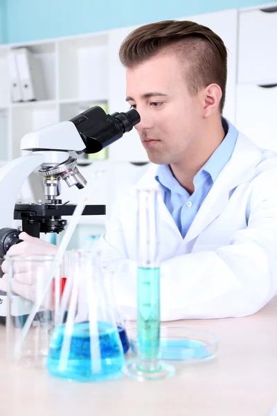 Cientista masculino usando microscópio em laboratório — Fotografia de Stock