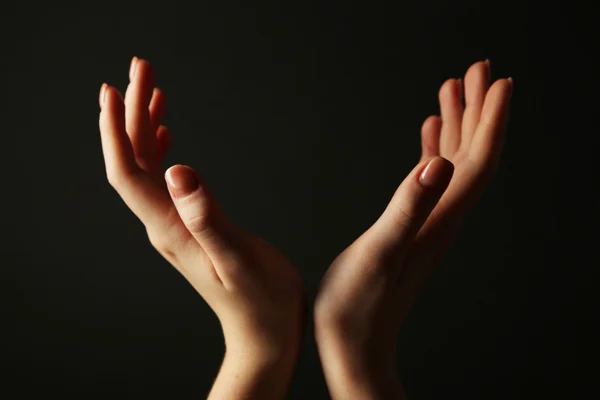 Manos femeninas sobre fondo oscuro — Foto de Stock