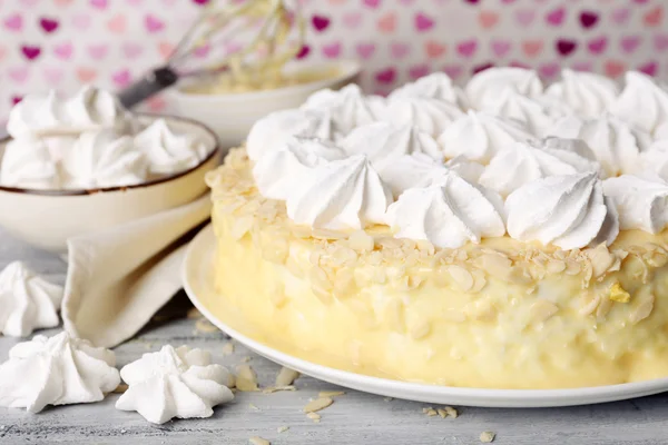 Tasty homemade meringue cake on wooden table, on pink background — Stock Photo, Image