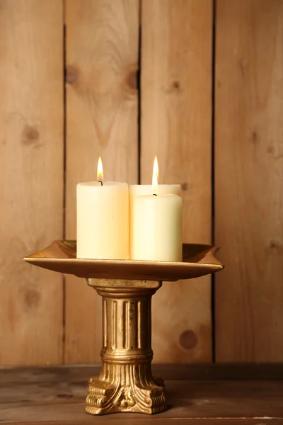 Castiçal retro com velas no fundo de madeira — Fotografia de Stock