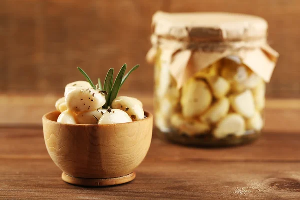 Ajo enlatado en frasco de vidrio y tazón sobre fondo de madera — Foto de Stock