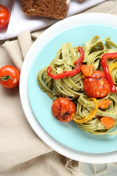 Smakelijke pasta met peper, wortel en tomaten op houten tafel achtergrond — Stockfoto