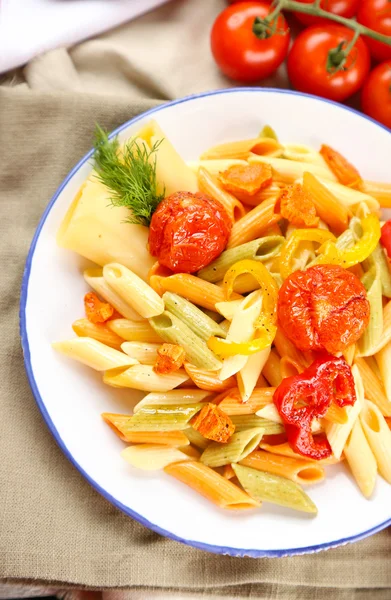 Pastasalade met peper, wortel en tomaten op houten tafel achtergrond — Stockfoto