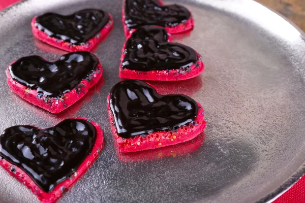 Cookies in form of heart covered chocolate on metal tray background — Stock Photo, Image