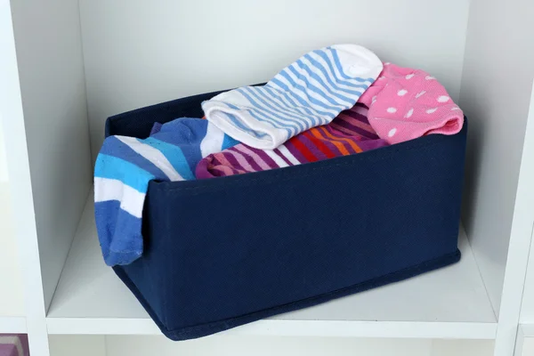 Different socks in textile box on closet background — Stock Photo, Image