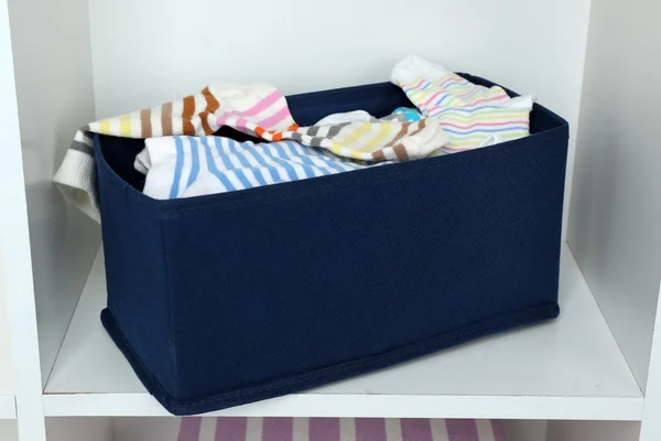 Различные носки в текстильной коробке на фоне шкафа — стоковое фото