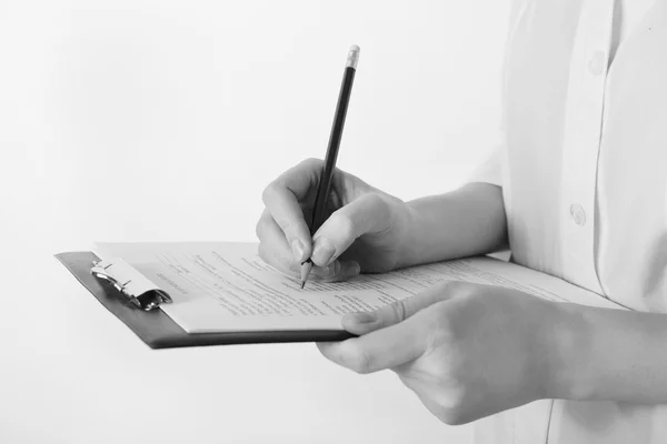 Doctor writing on clipboard on light background — Stock Photo, Image