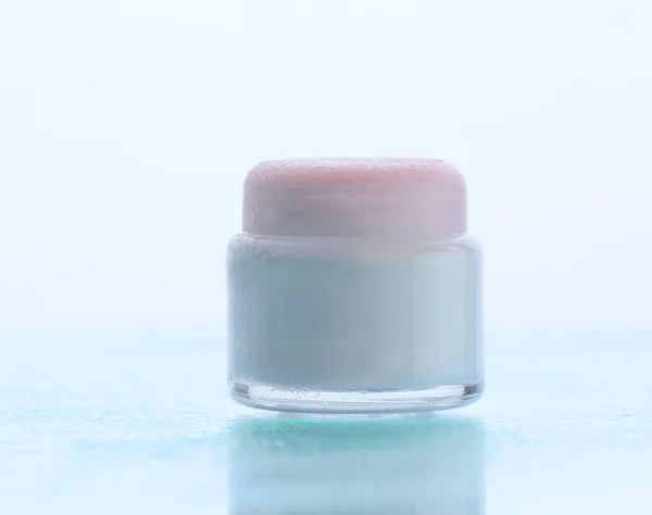 Creme cosmético em fundo azul com gotas de água — Fotografia de Stock