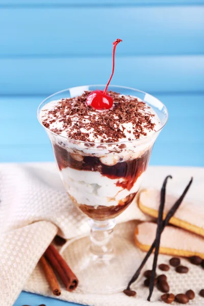 Tasty tiramisu dessert in glass, on color wooden background — Stock Photo, Image