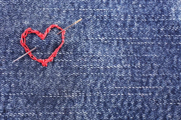 Jeansstoff mit aufgesticktem roten Herz, Nahaufnahme — Stockfoto