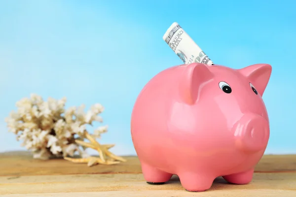 Piggy bank on wooden table, outdoors — Stock Photo, Image