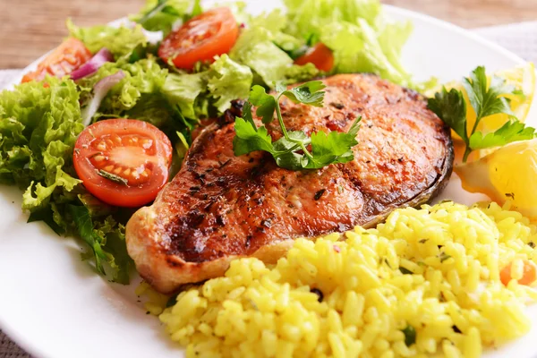 Tasty ugnsbakad fisk med ris på tallriken på bordet närbild — Stockfoto