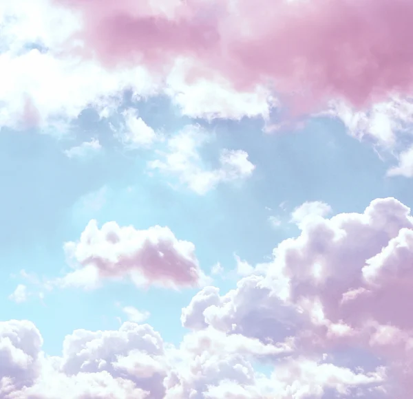 Blauwe hemelachtergrond met roze wolken — Stockfoto