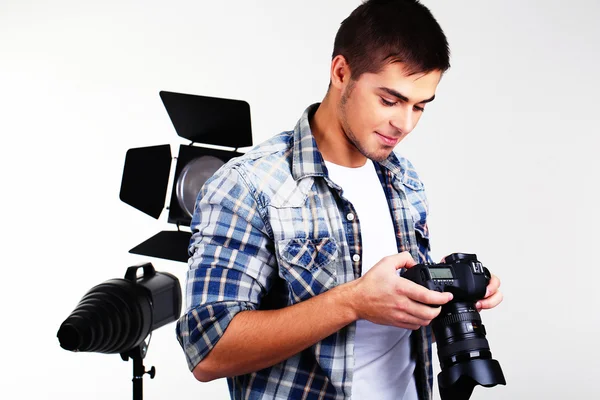 Fotógrafo guapo con cámara en estudio fotográfico —  Fotos de Stock