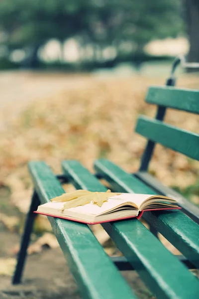 Book with leaf on bench — Stock Photo, Image