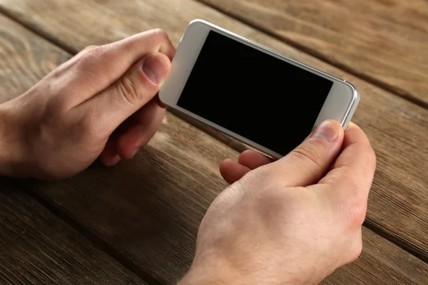 Manos sosteniendo el teléfono móvil inteligente — Foto de Stock