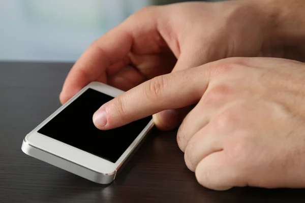 Manos sosteniendo el teléfono móvil inteligente — Foto de Stock