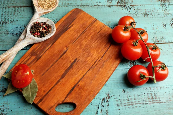 Différentes épices et herbes avec planche à découper sur fond de table en bois couleur — Photo